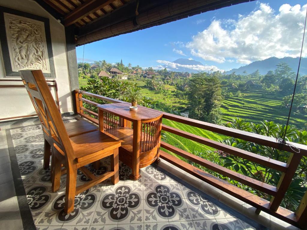 einen Balkon mit einem Holztisch und einem Stuhl sowie Aussicht in der Unterkunft Abian Ayu Villa in Sidemen