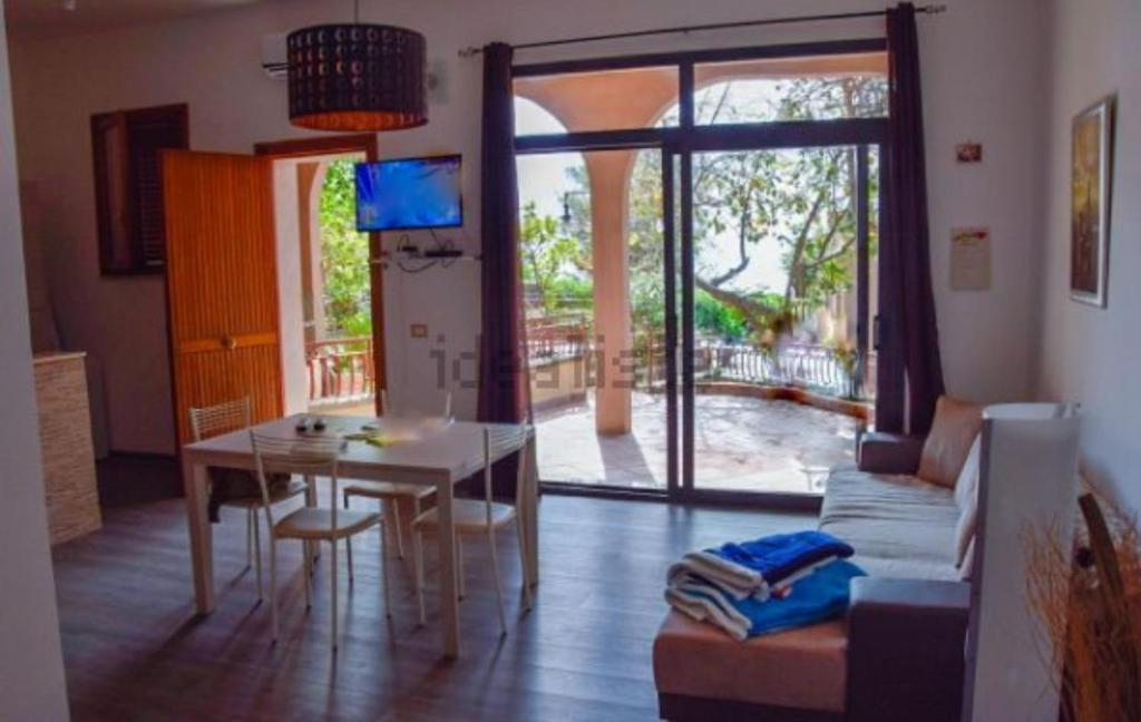 ein Wohnzimmer mit einem Tisch, einem Sofa, einem Tisch und einem Esszimmer in der Unterkunft Elegance apartment Taormina in Letojanni