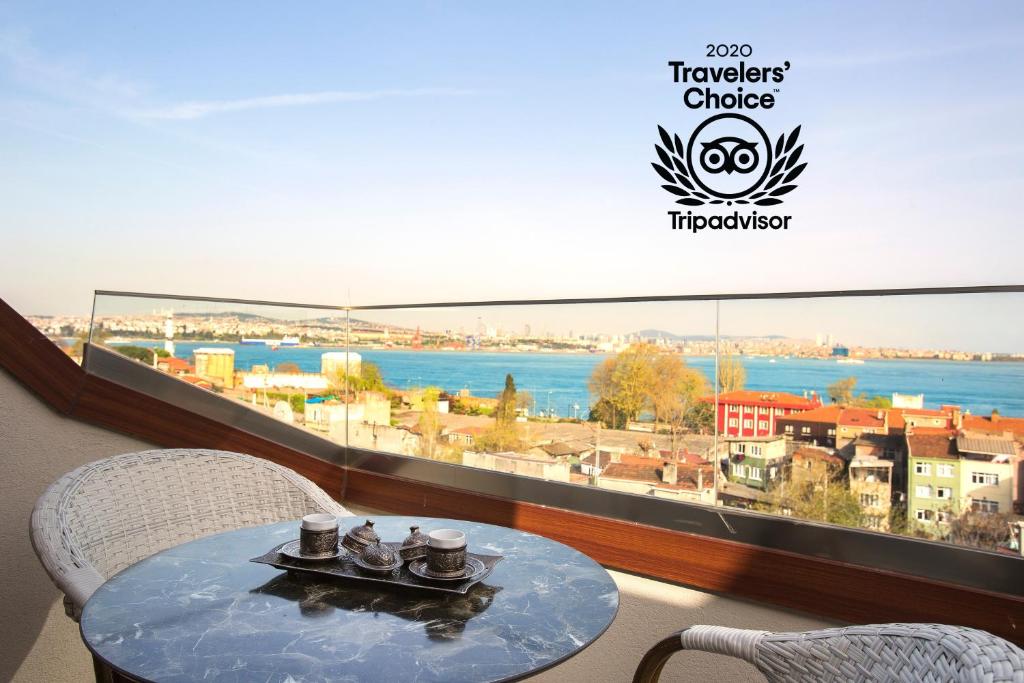 イスタンブールにあるAcra Hotel - Special Categoryの大きな窓のある客室で、テーブルと椅子が備わります。