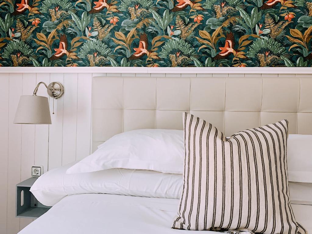 1 dormitorio con 1 cama y papel pintado con motivos florales en Boutike Guesthouse, en Sevilla