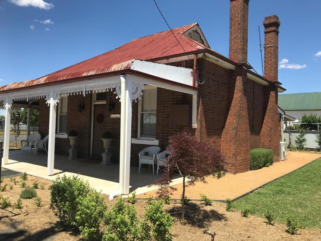 an old brick house with a red roof at Woodstock Cottage in Temora