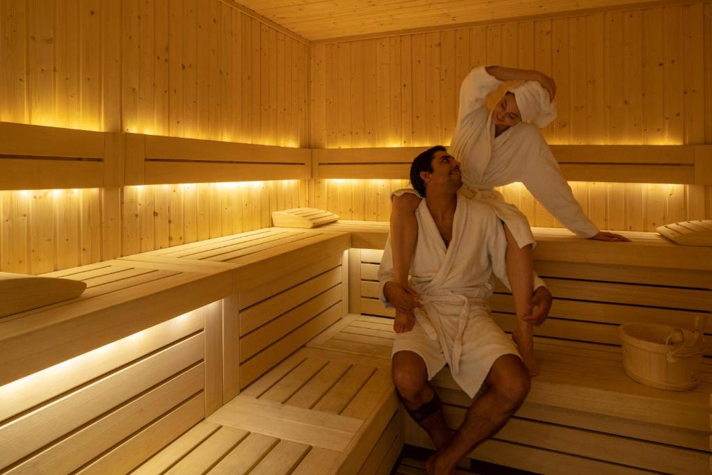 a man and a woman sitting in a sauna at Coco-mat Athens BC in Athens