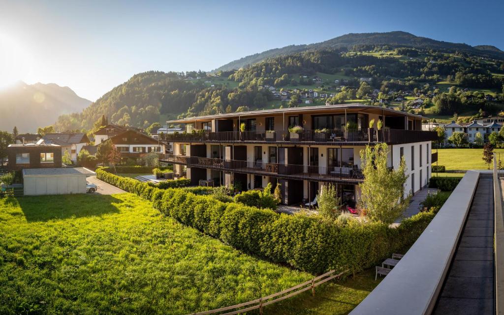 a building with a hedge in front of a mountain at Krone Apartments Top 6 / Top 7 / Top 8 in Schruns