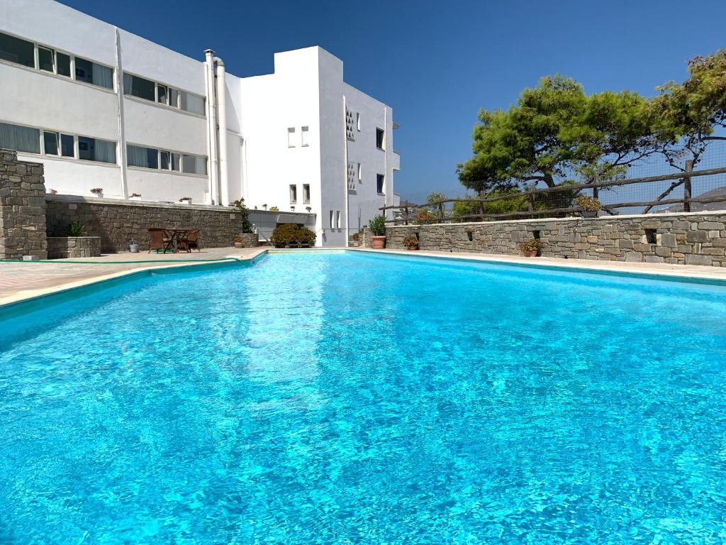 a swimming pool in front of a building at Pandrossos Hotel - Paros in Parikia