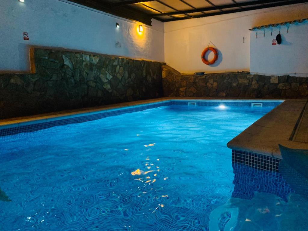 uma grande piscina com água azul num quarto em Puerta del Agua em Uclés