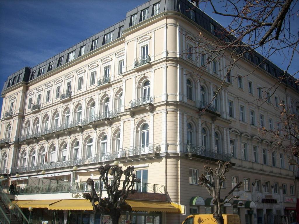 een groot wit gebouw met veel ramen bij Garconniere im ehemaligen Hotel Austria in Gmunden