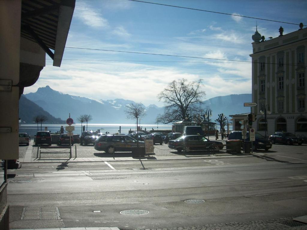 a parking lot with cars parked in front of the water at Garconniere im ehemaligen Hotel Austria in Gmunden