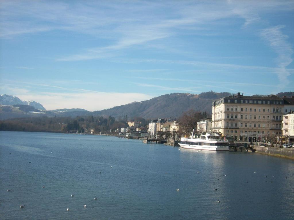 a river with a boat in the middle of a city at Garconniere im ehemaligen Hotel Austria in Gmunden