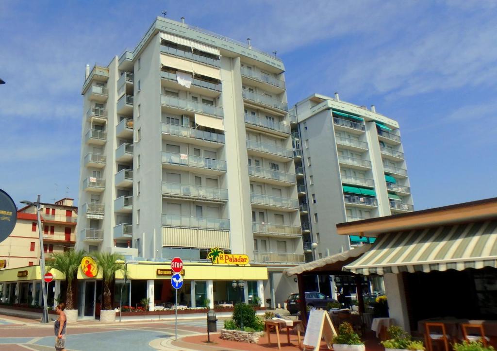 dwa wysokie budynki w mieście z kobietą idącą przed w obiekcie Cortina 1-46 w mieście Lido di Pomposa