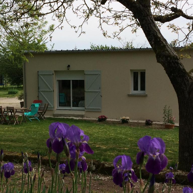 une maison avec des fleurs violettes devant dans l'établissement la Sainterie, à Savonnières
