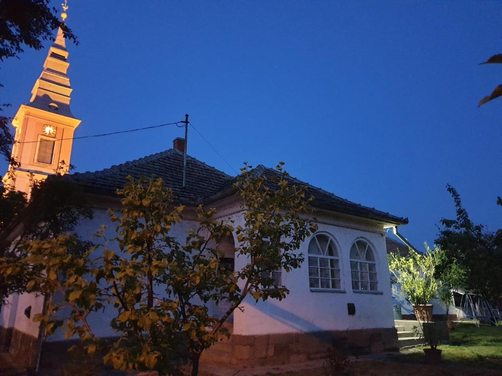 Una iglesia con un campanario encima. en Mélyvíz II Apartman, en Poroszló