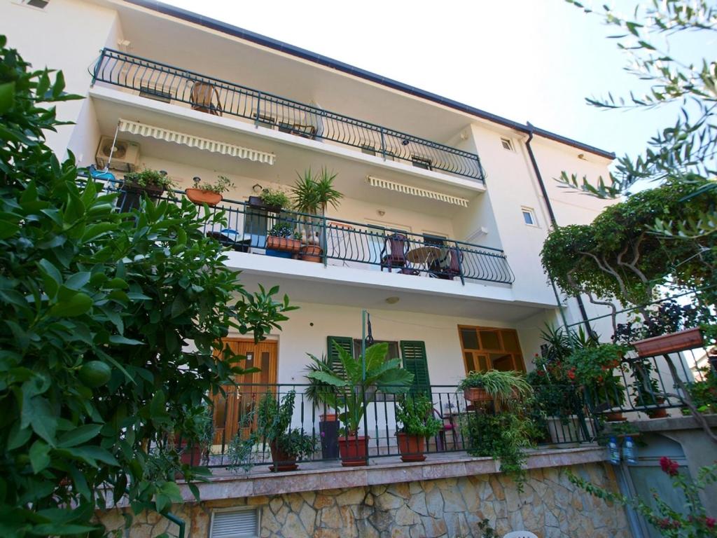 a building with potted plants on its balconies at Apartmani Danica in Gradac