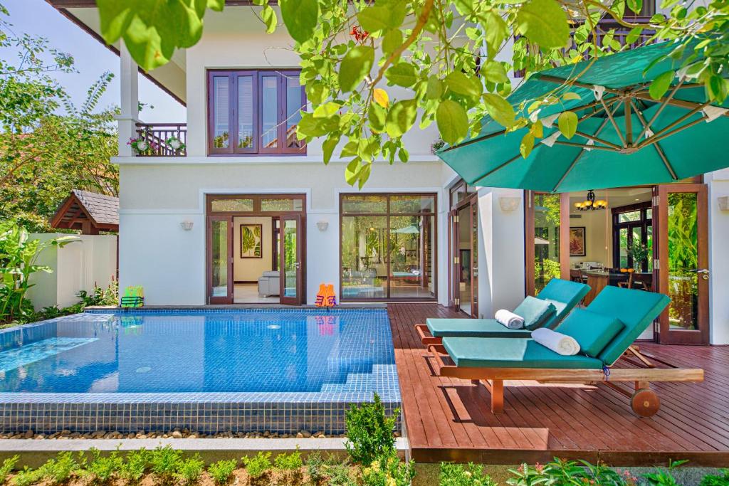 a villa with a swimming pool and a house at Abogo Resort Villas Luxury Da Nang in Danang