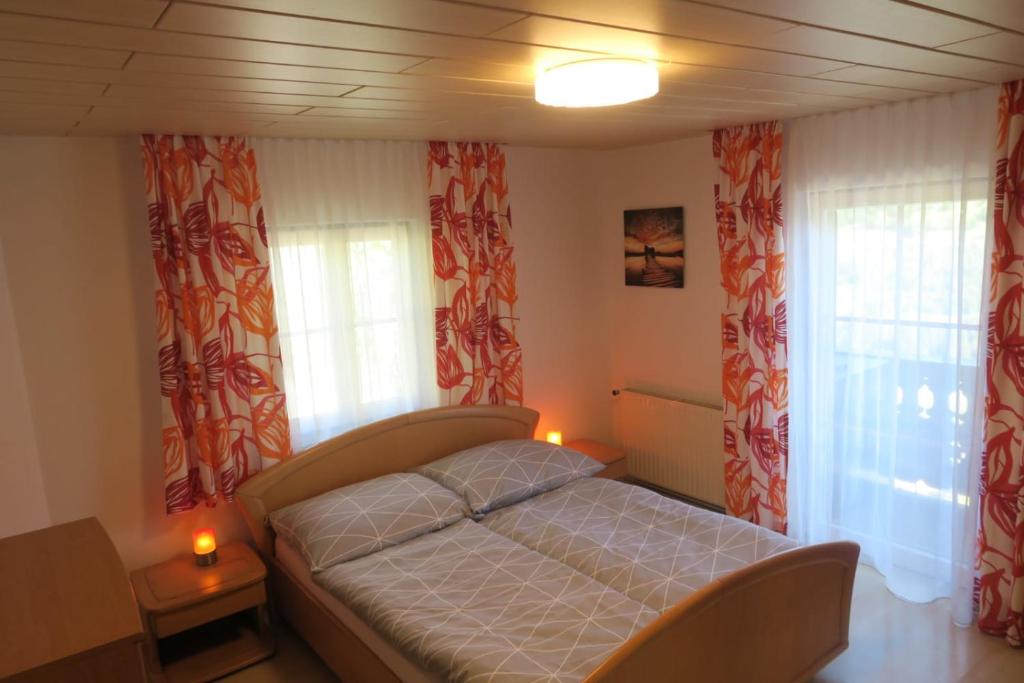 een kleine slaapkamer met een bed en 2 ramen bij Appartment Brigitte in Bad Gastein
