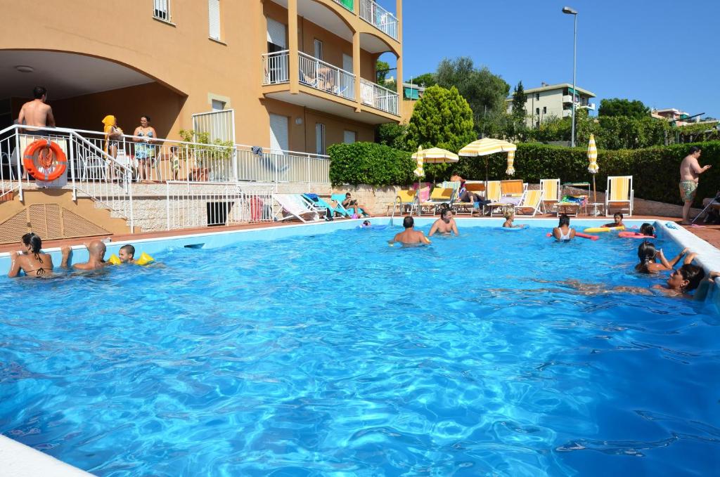 eine Gruppe von Personen, die in einem Schwimmbad schwimmen in der Unterkunft Residence Orchidea in Pietra Ligure