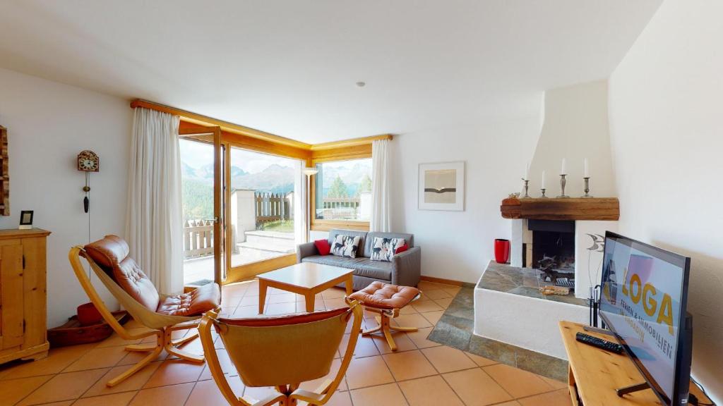 uma sala de estar com TV e lareira em Abitaziun Murinella - Pontresina em Pontresina