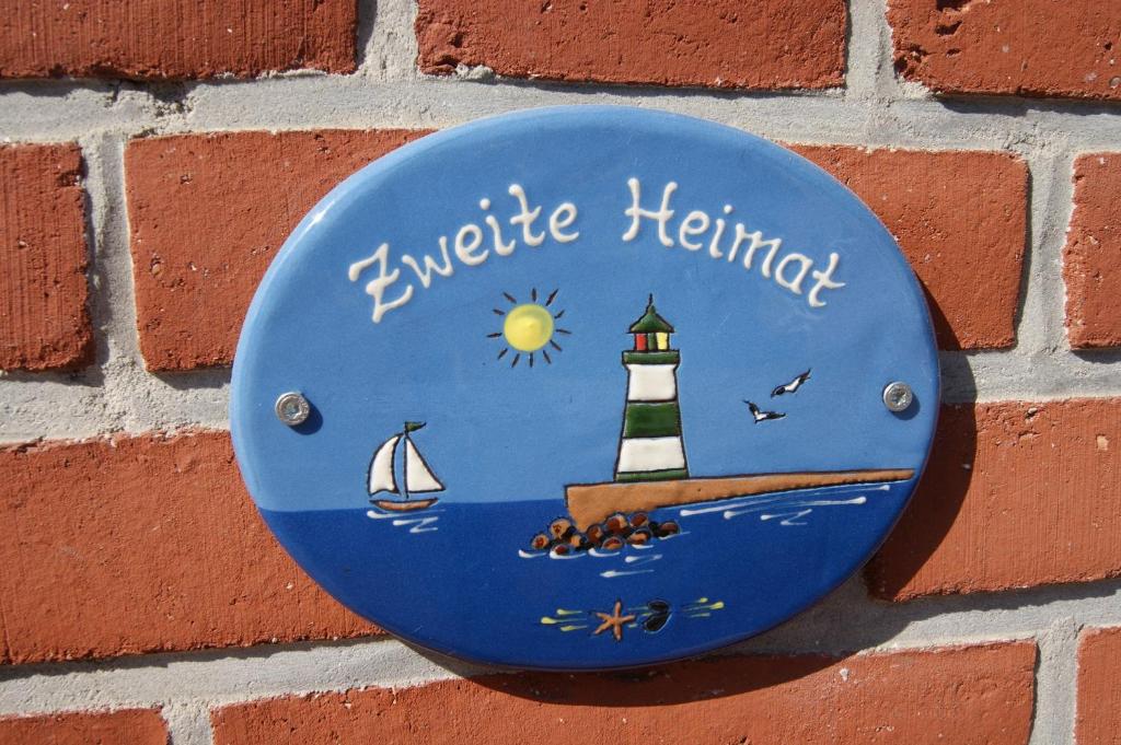 a blue plate with a lighthouse on a brick wall at Ferienhof Schulz in Brodersby OT Schönhagen