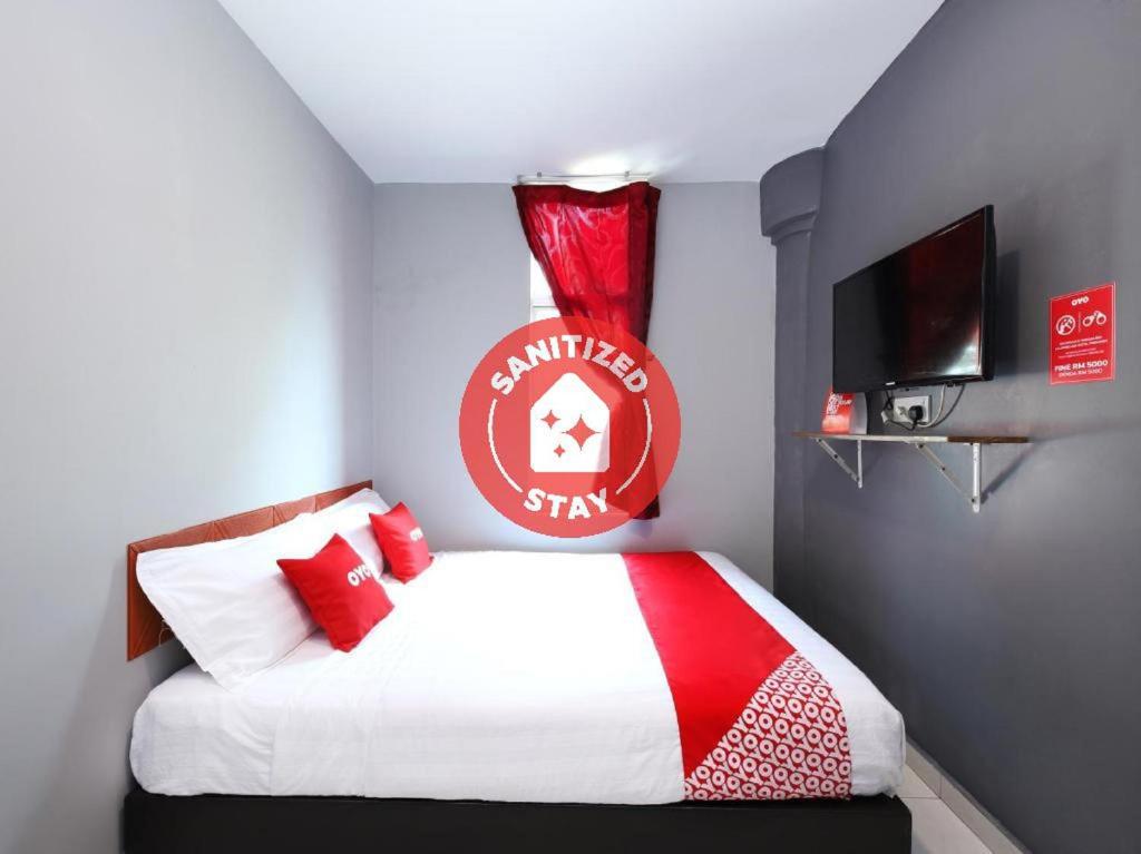 a bedroom with a bed with a football sign on the wall at Super OYO 1184 Ho Hotel in Melaka