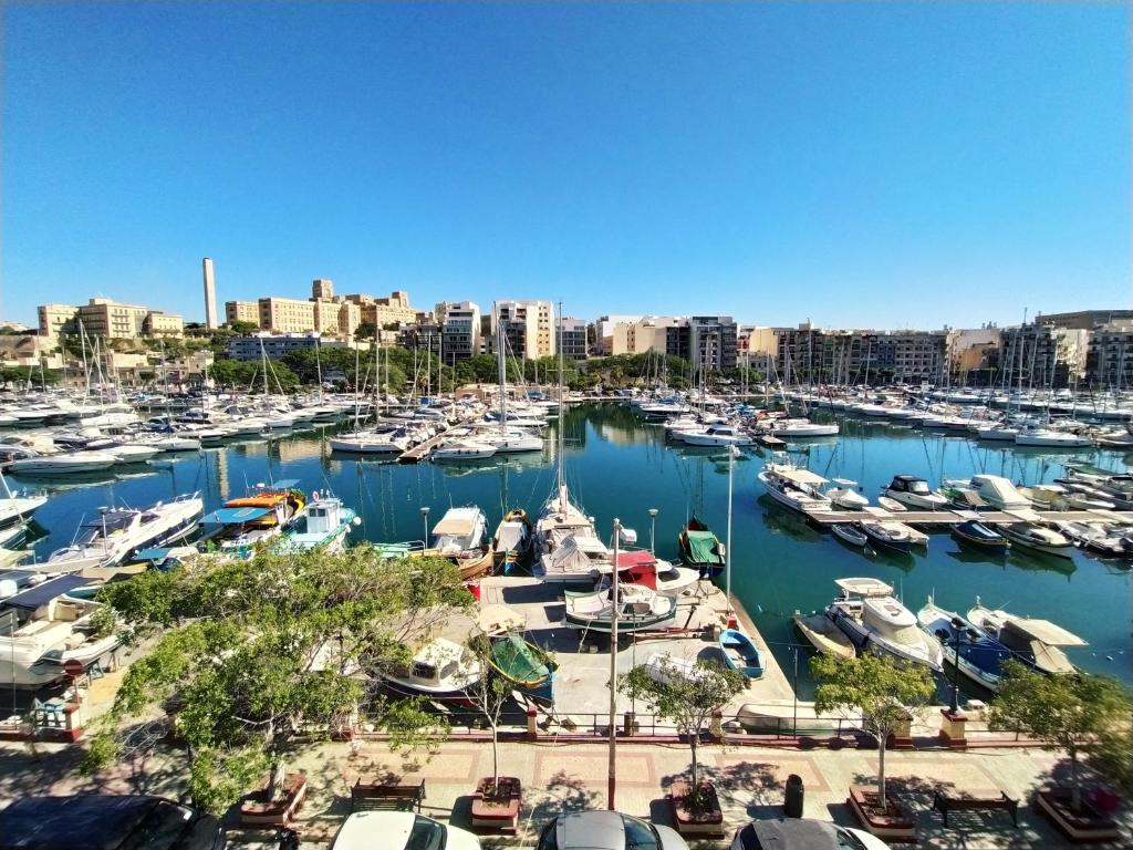 un porto pieno di barche in una città di 2 Bedroom, Central and Spacious Apartment with Sea View - 2 a Msida