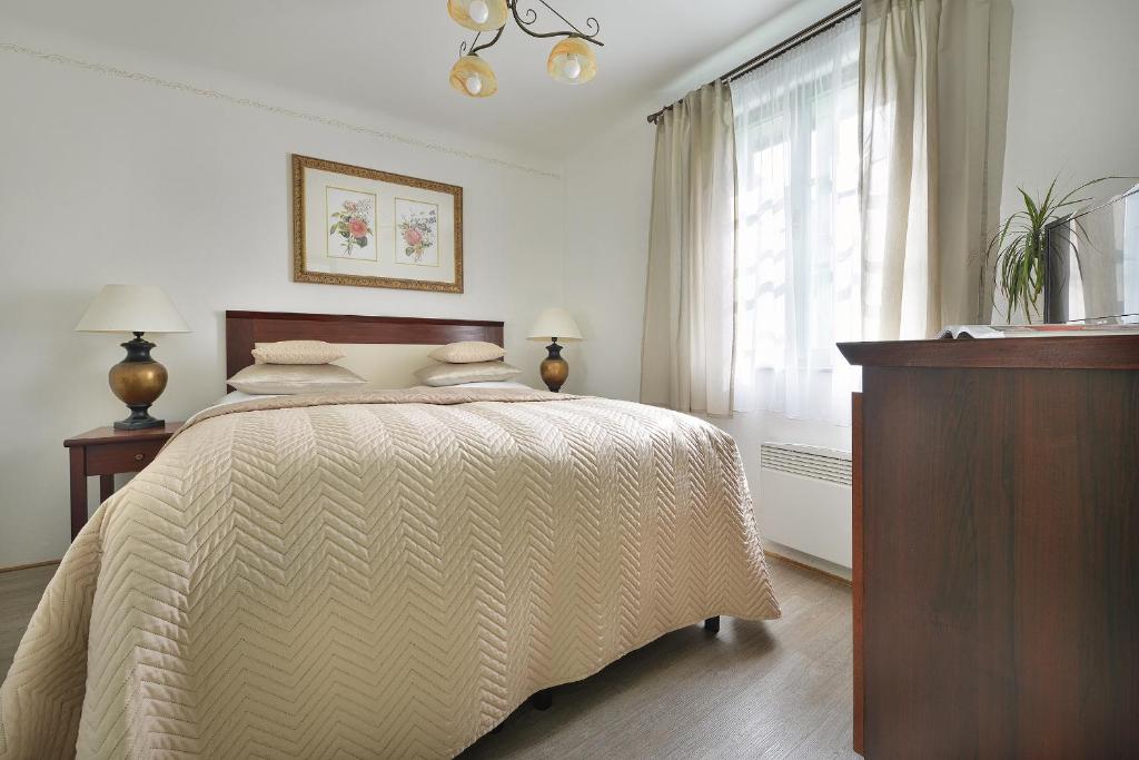 a bedroom with a bed and a dresser and a window at Nobles Apartments in Prague