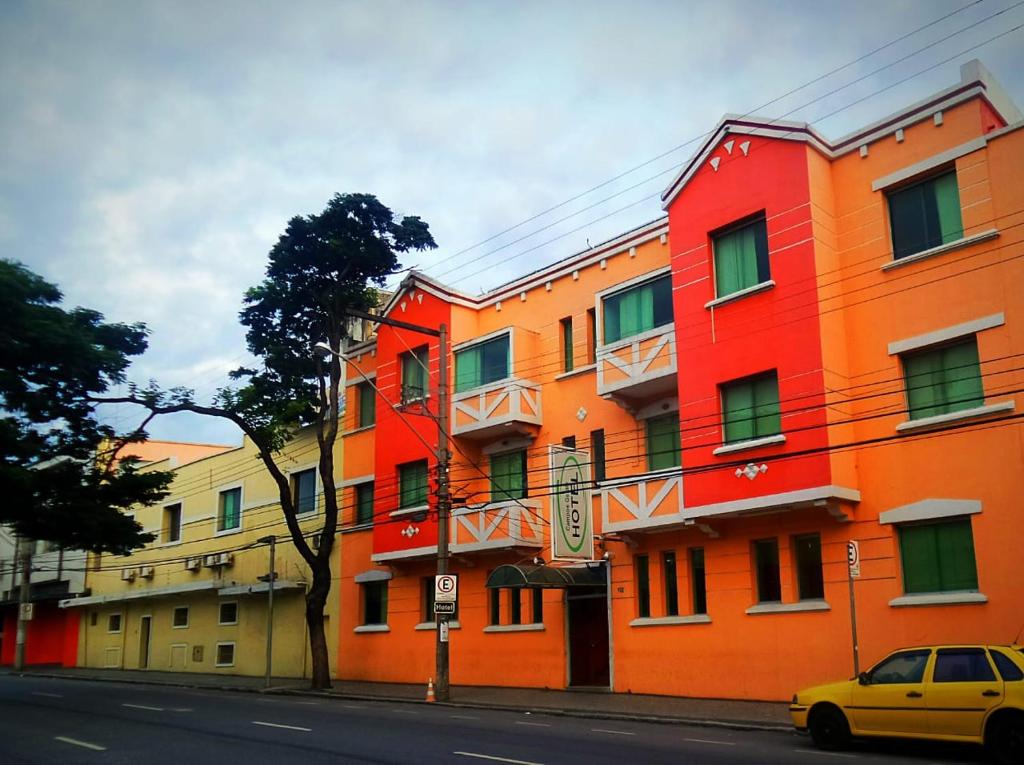 un edificio naranja al lado de una calle en Campos Gerais Hotel, en Belo Horizonte
