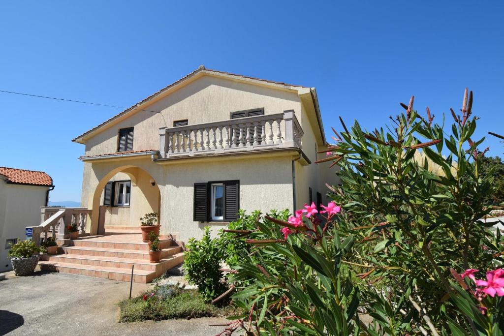 une maison avec balcon et quelques fleurs dans l'établissement Apartment Pampas, à Omišalj