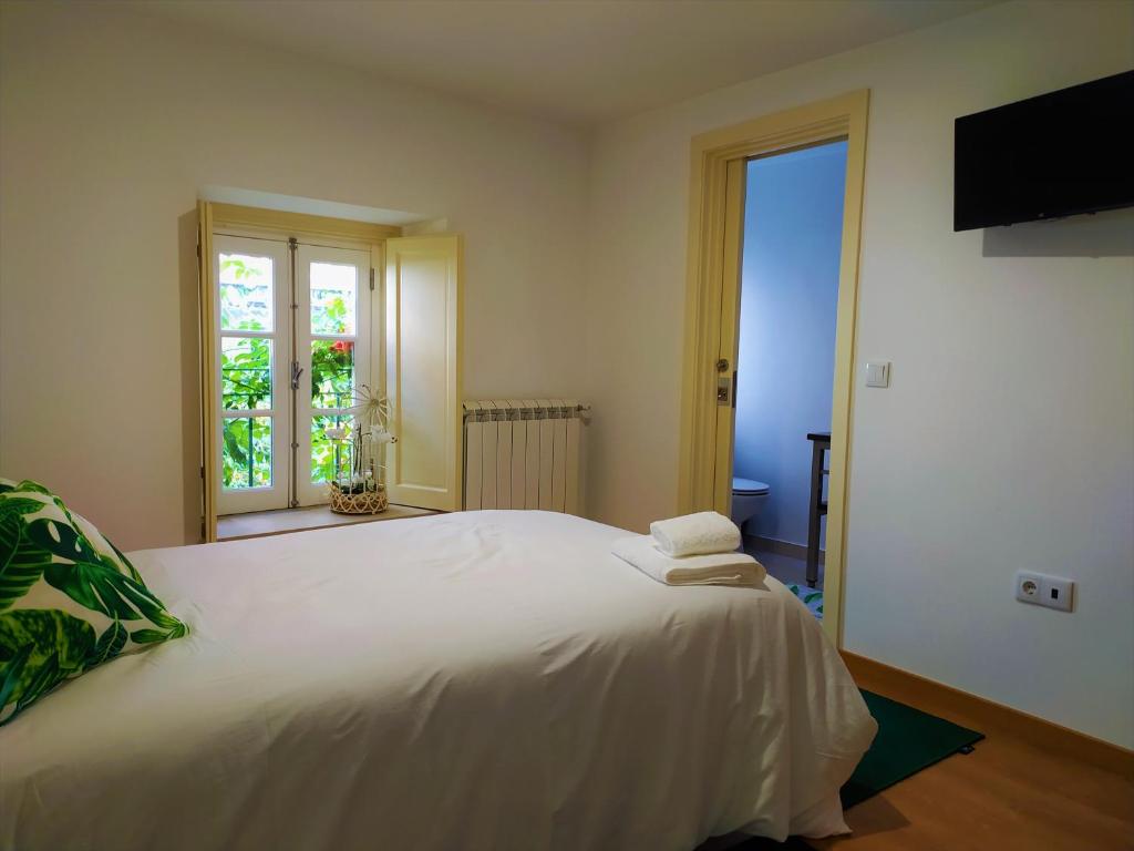 a large white bed in a room with a window at Casa do Castelo Ourém in Ourém