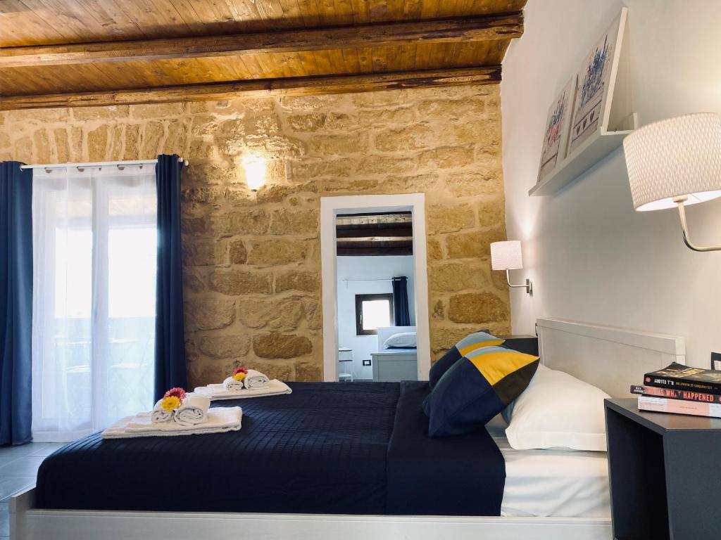 een slaapkamer met een bed en een stenen muur bij B&B Donna Teresa in Agrigento