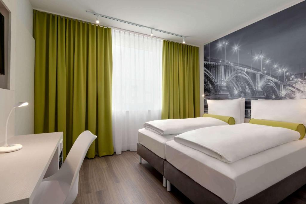 1 dormitorio con 2 camas y cortina verde en Super 8 by Wyndham Mainz Zollhafen en Mainz