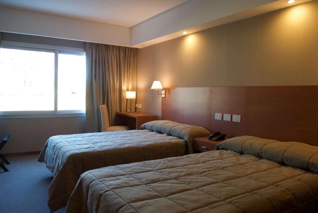 Habitación de hotel con 3 camas y ventana en Howard Johnson Marinas & Resort en San Pedro