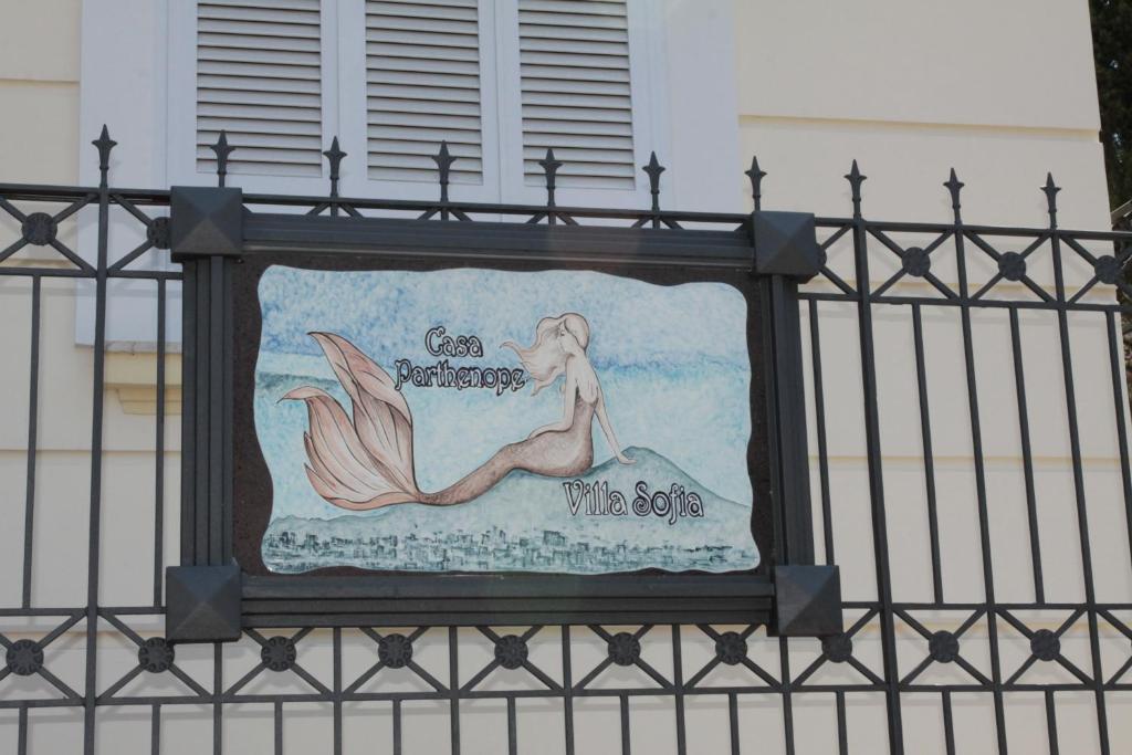 Een teken op een hek met een zeemeermin erop. bij Casa Parthenope in Ercolano