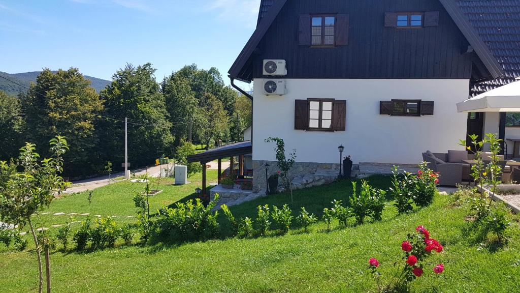 uma casa com um jardim em frente em B&B Plitvice Lakes Villa Prica em Plitvica selo