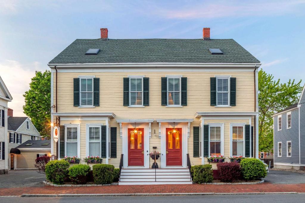 a house with a red door on a street at Essex Street Inn & Suites, Ascend Hotel Collection in Newburyport
