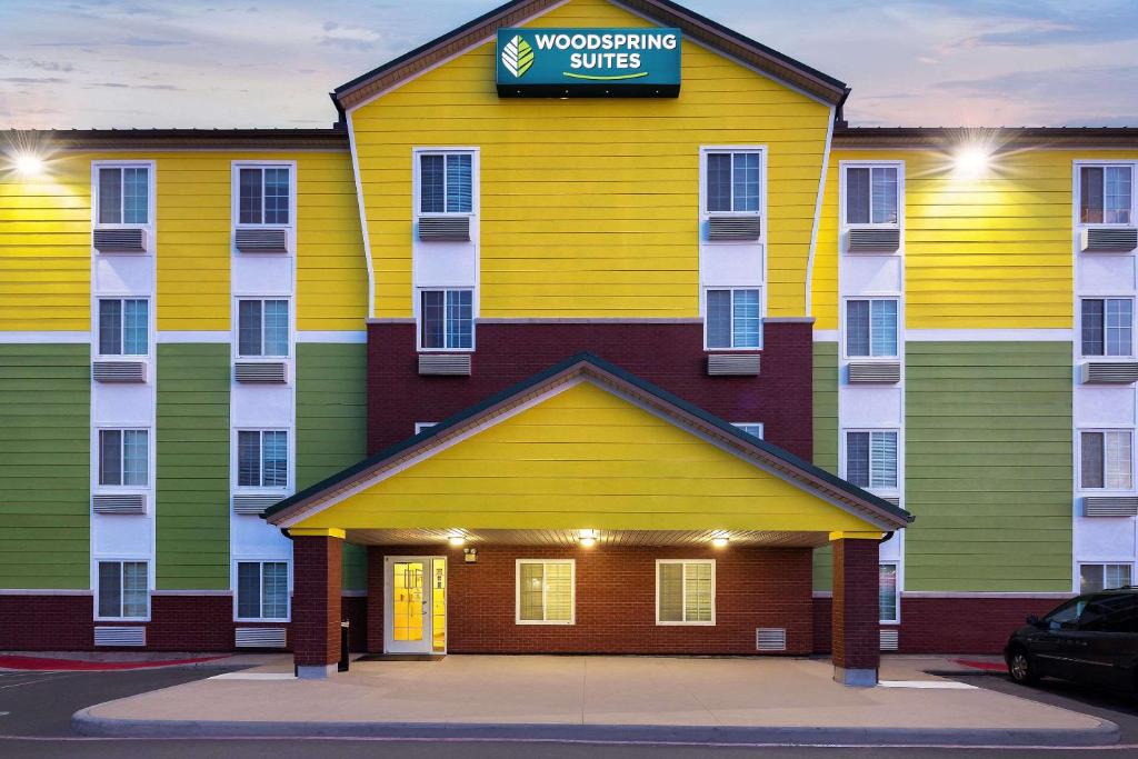 a colorful building with a sign on it at WoodSpring Suites Tyler Rose Garden in Tyler