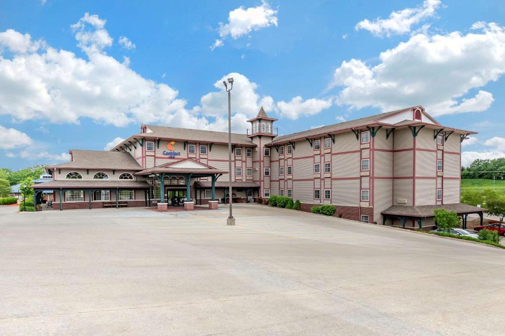 um grande edifício cor-de-rosa com estacionamento em Comfort Inn Warrensburg Station em Warrensburg