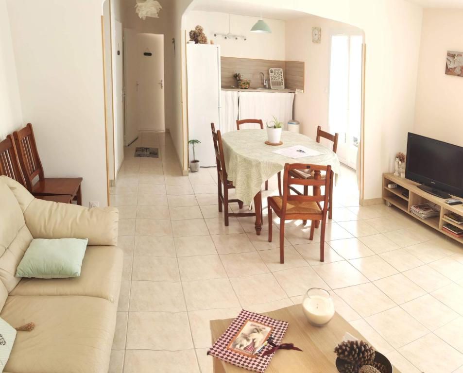 Il comprend un salon et une cuisine avec une table et des chaises. dans l'établissement LE CLOS VARNAY, à Meusnes
