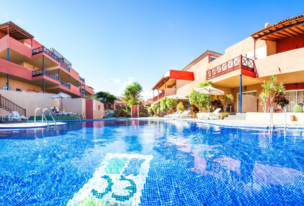 a swimming pool in front of a hotel at Aparthotel El Cerrito in Los Cancajos