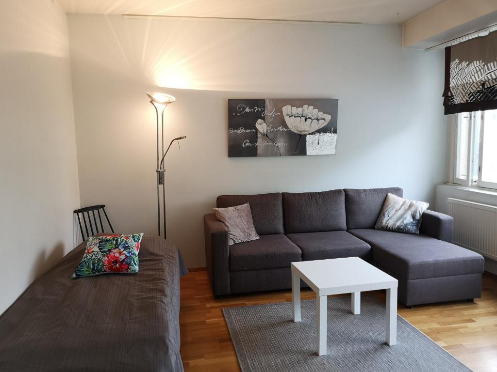 uma sala de estar com um sofá e uma mesa em Apartment Asemakatu 20 em Kuopio