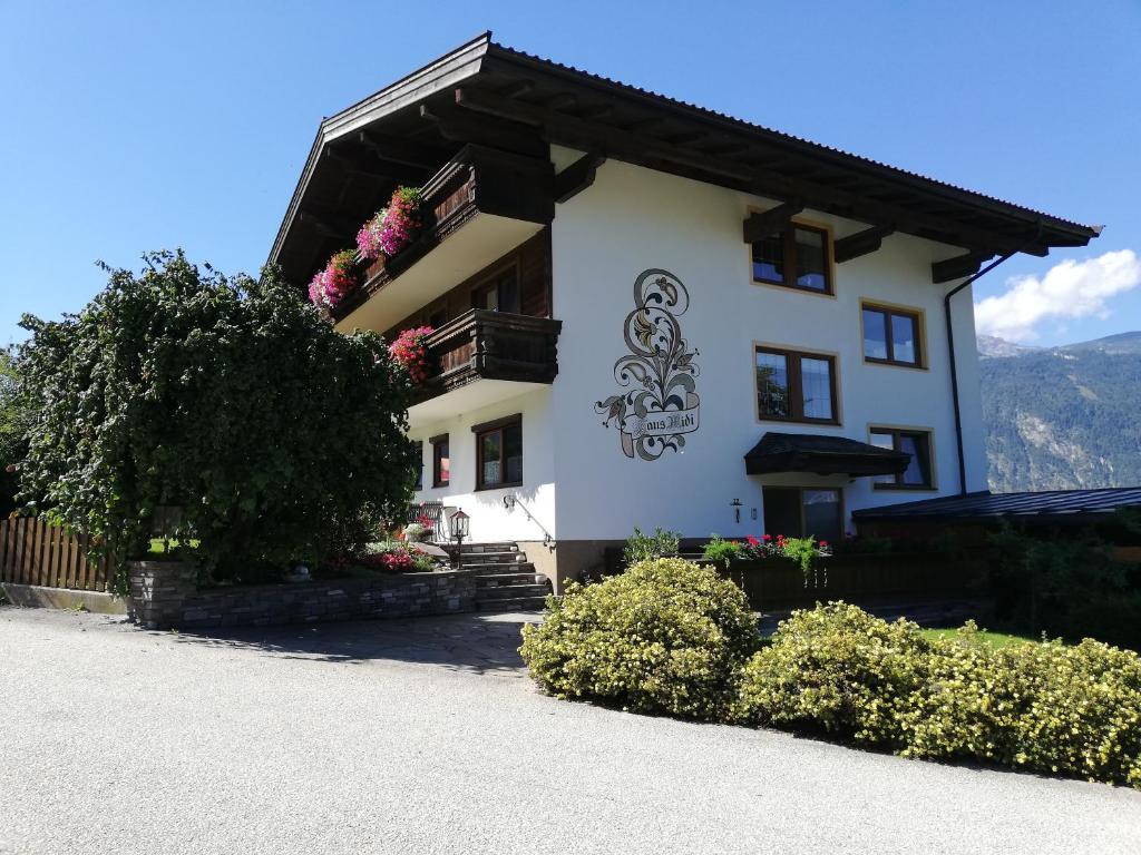 a white house with flowers on the side of it at Gästehaus Midi in Reith im Alpbachtal