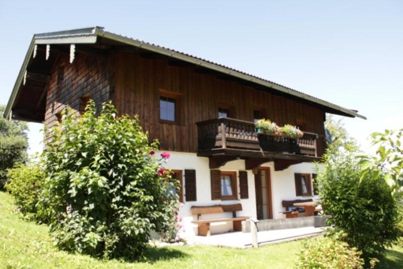 uma grande casa de madeira com um alpendre e uma varanda em Ferienwohnung Hallweger em Ruhpolding