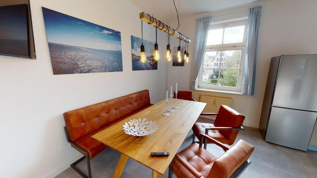 uma sala de jantar com uma mesa e um frigorífico em Lieblingsapartment mit 2 Schlafzimmern - Nördliche Altstadt in Rostock em Rostock