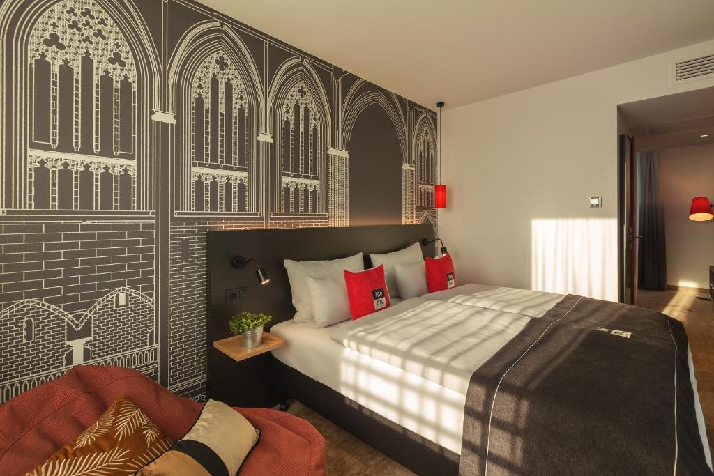 een slaapkamer met een bed en een muur met bij the niu Sparrow in Regensburg