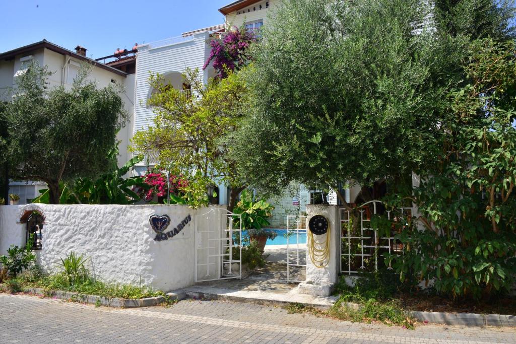 a white fence with a gate in front of a house at Aquarius Hotel in Side