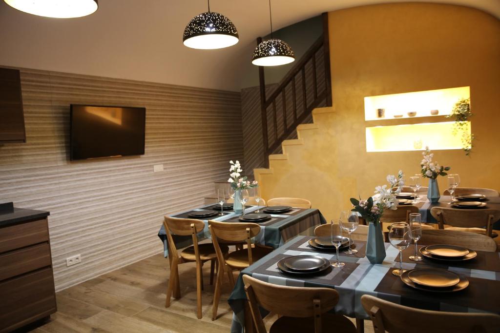 a dining room with tables and chairs and a television at Bienestar House in Blanes