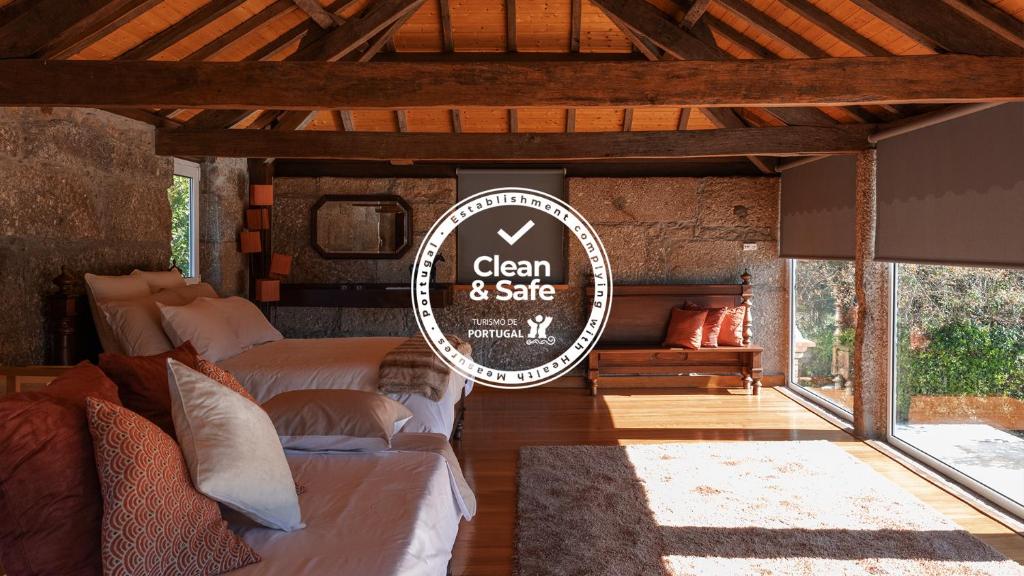 a room with two beds and a sign that reads clean and safe at O Sequeiro in Vila Nova de Famalicão