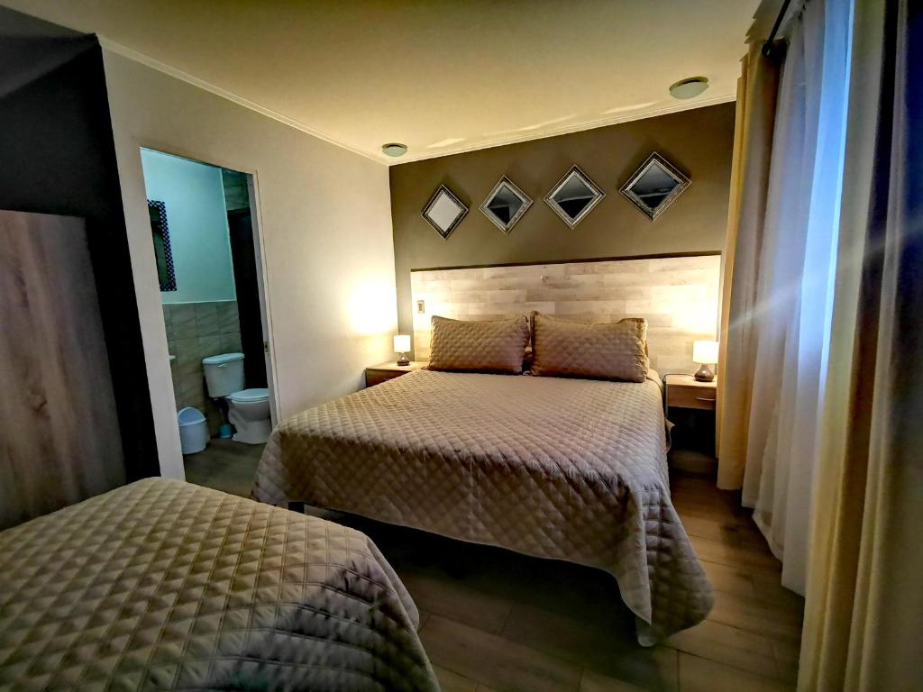 Habitación de hotel con 2 camas y espejo en Doña Francisca en Arica