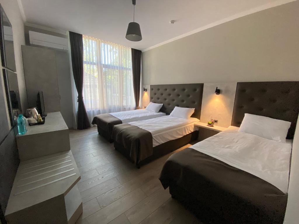 a hotel room with two beds and a window at Comfort Guest Rooms in Kazanlŭk