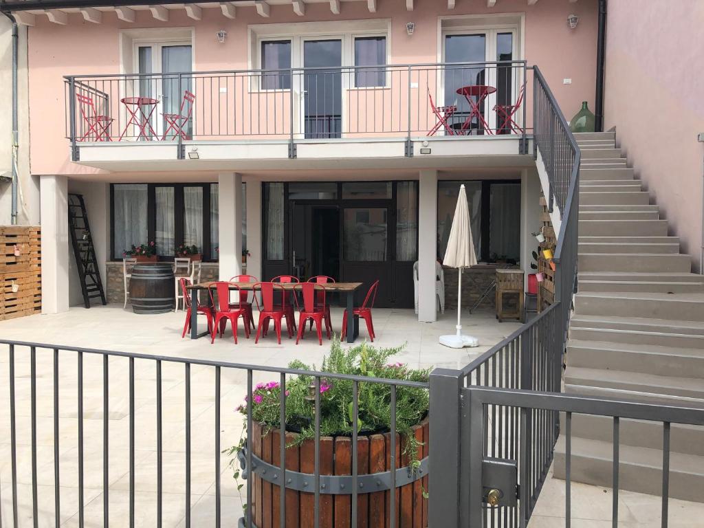 een balkon met rode stoelen en tafels op een huis bij B&B Corte del Garda in Castelnuovo del Garda