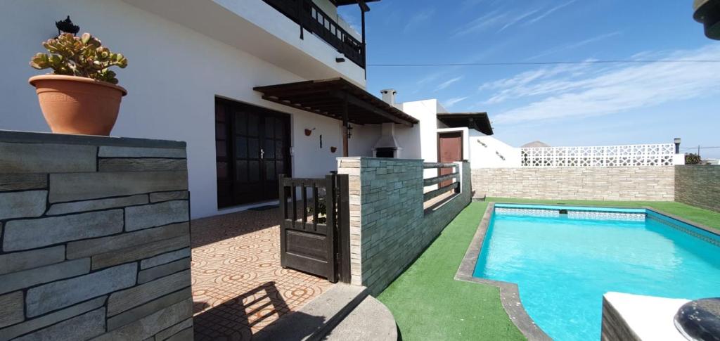 a villa with a swimming pool and a house at Casa Andres in La Asomada