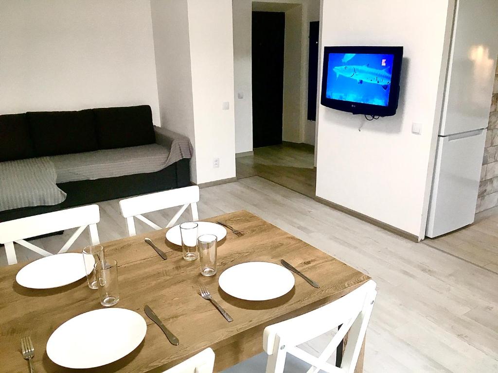 a living room with a wooden table with white plates on it at Loft 2кімнатні Апартаменти Сучасний ремонт WiFi in Chernihiv